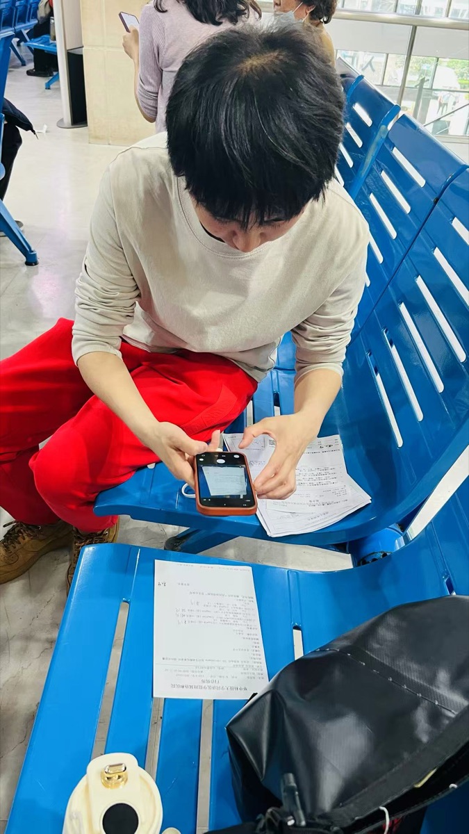 陪诊师在候诊区整理手机信息与纸质单据