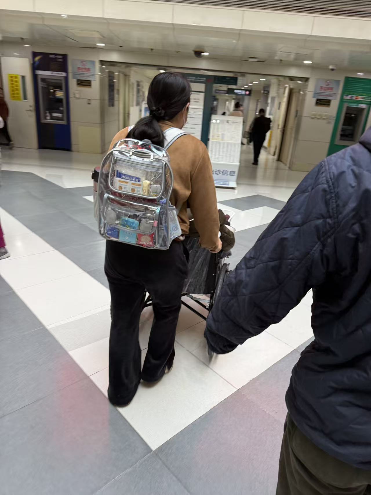 陪诊师陪同坐轮椅患者在诊室内就诊