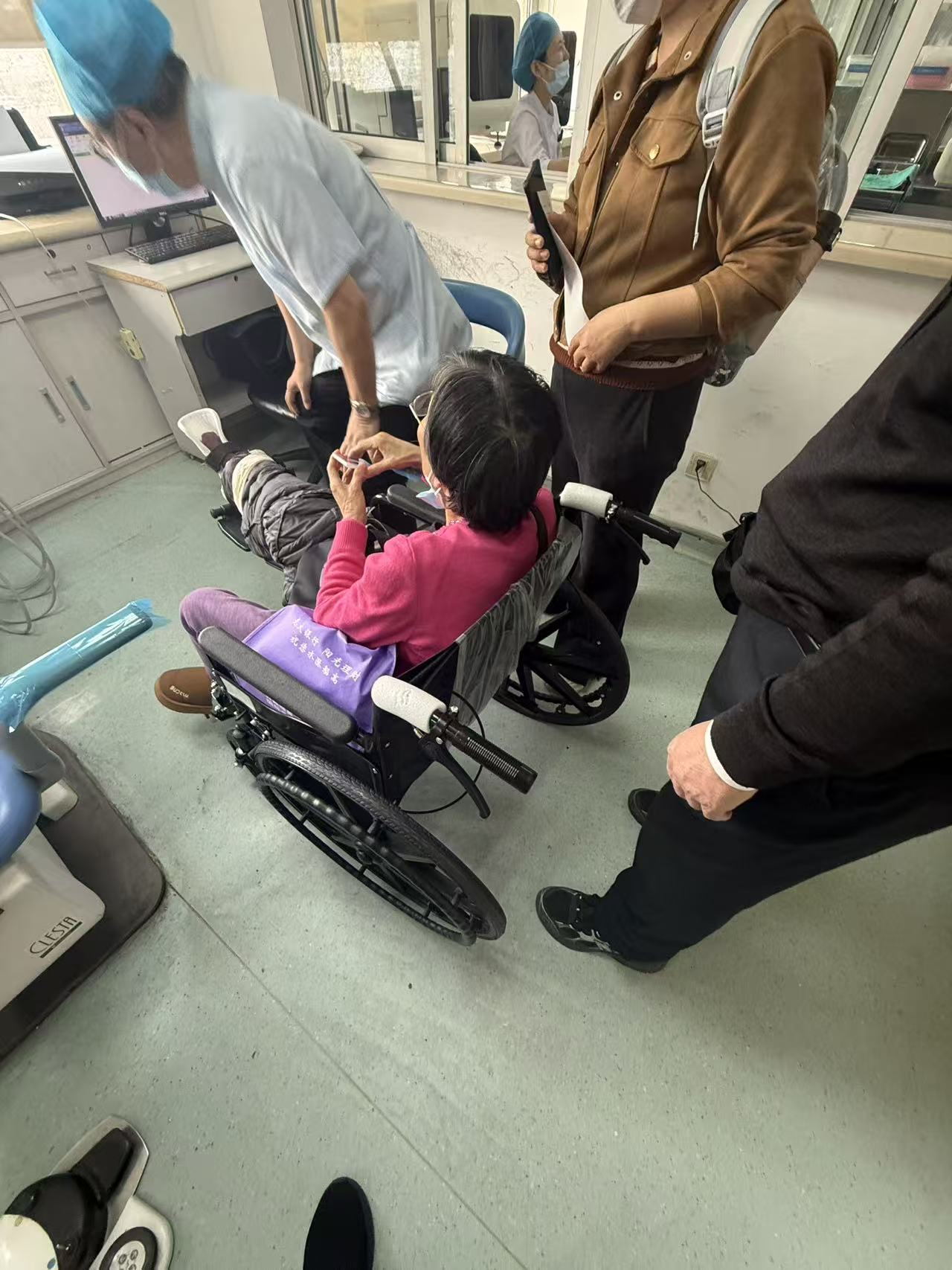 陪诊师在医院走廊推行轮椅陪同患者就医